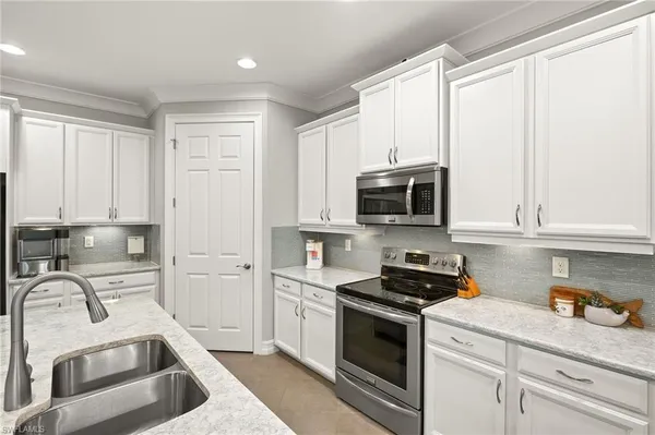 a kitchen with stainless steel appliances white cabinets and a stove top oven
