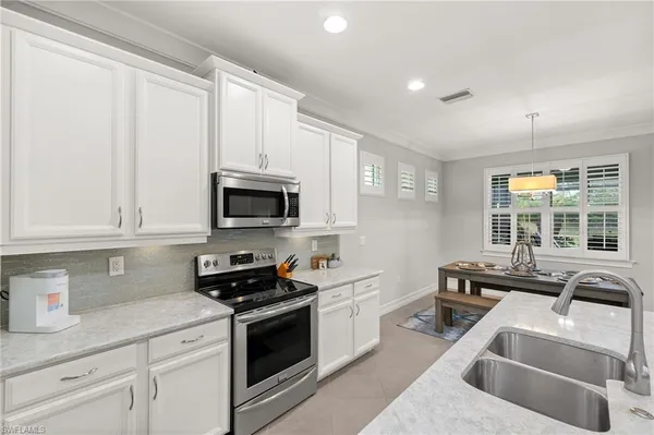 a kitchen with stainless steel appliances granite countertop a sink a stove and a refrigerator