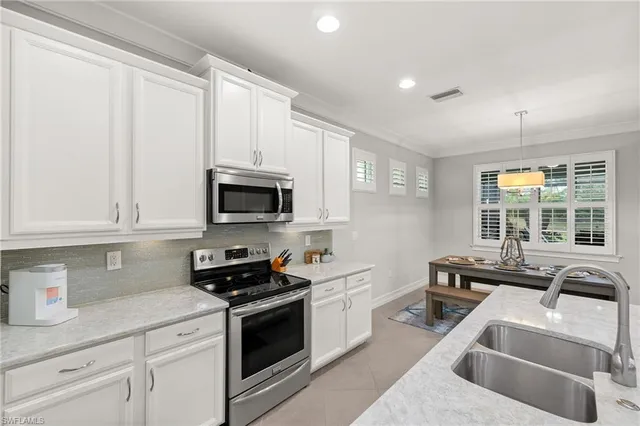a kitchen with stainless steel appliances granite countertop a sink a stove and a refrigerator