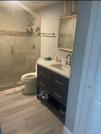 a bathroom with a granite countertop toilet sink and mirror