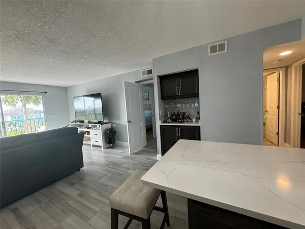 a living room with stainless steel appliances kitchen island granite countertop furniture and a kitchen view