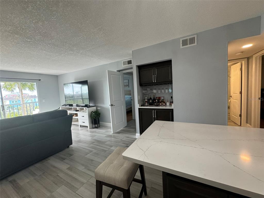 5537 Sea Forest Drive, Unit 208 New Port Richey, FL 34652 - Photo 14 of 26 a living room with stainless steel appliances kitchen island granite countertop furniture and a kitchen view