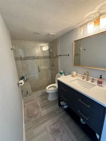 a bathroom with a double vanity sink toilet mirror and shower