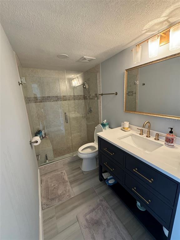 5537 Sea Forest Drive, Unit 208 New Port Richey, FL 34652 - Photo 18 of 26 a bathroom with a double vanity sink toilet mirror and shower