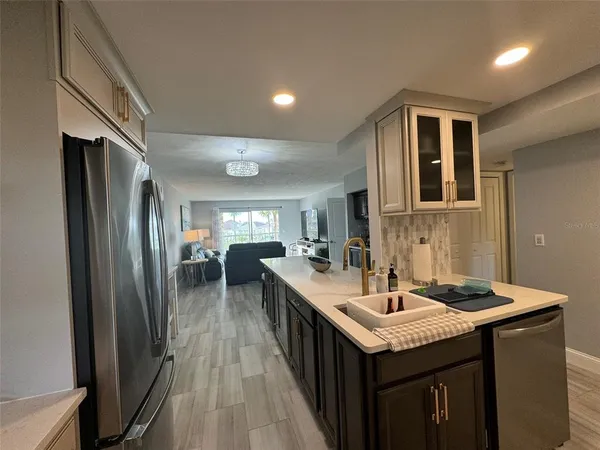 a kitchen with granite countertop a sink stove and refrigerator