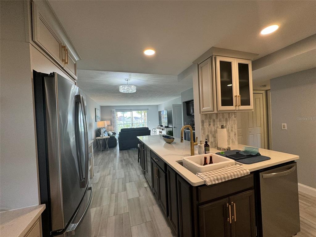 5537 Sea Forest Drive, Unit 208 New Port Richey, FL 34652 - Photo 6 of 26 a kitchen with granite countertop a sink stove and refrigerator