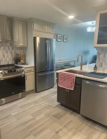 a kitchen with granite countertop a refrigerator stove and cabinets