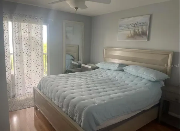 a large bed sitting in a bedroom next to a window