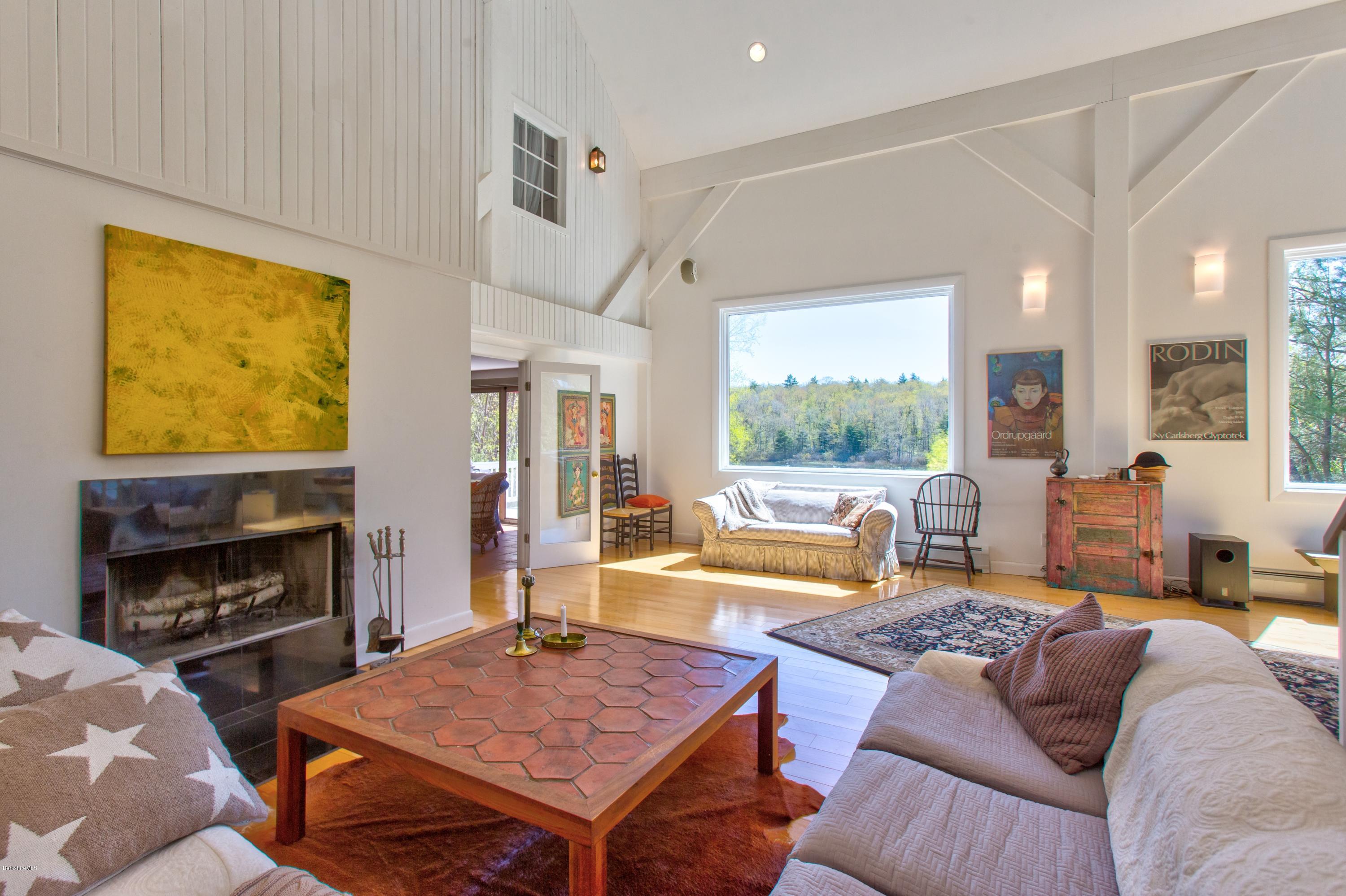 49 New Hartford Road Sandisfield, MA 01255 - Photo 16 of 41 a living room with furniture a large window and a fireplace