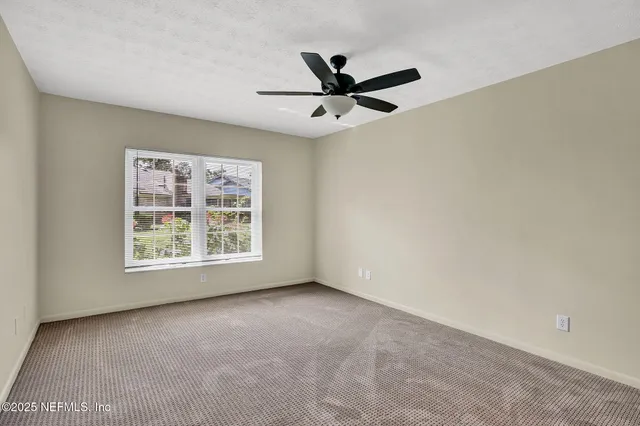 a view of a big room with wooden floor and windows