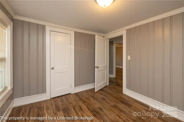 a view of an empty room with closet and a window