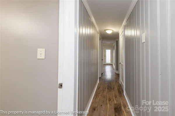 a view of a hallway with wooden floor