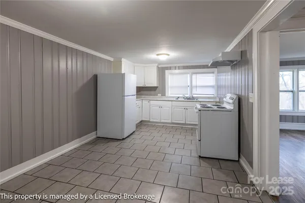a kitchen with a refrigerator a stove top oven and cabinets