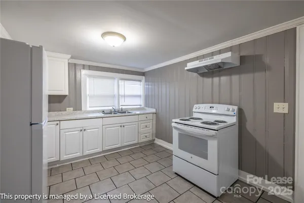 a kitchen with a stove sink and cabinets