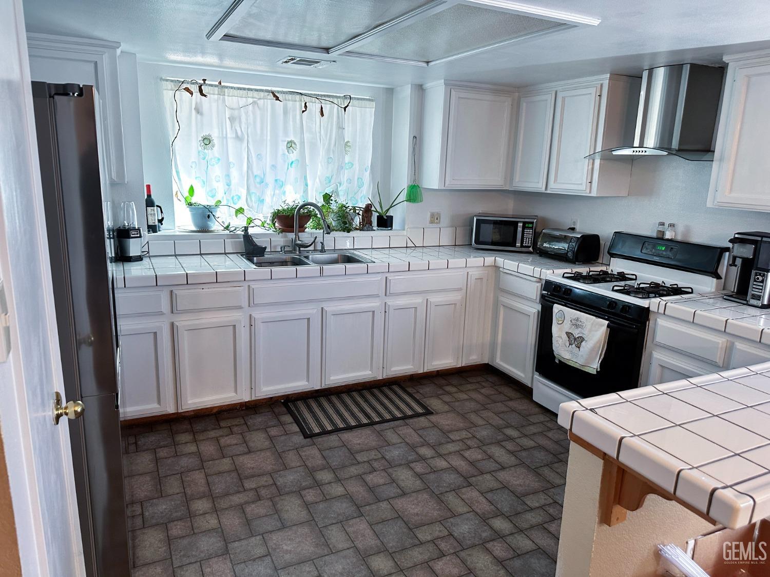 Undisclosed Address Shafter, CA 93263 - Photo 11 of 14 a kitchen with a sink a stove a refrigerator and cabinets