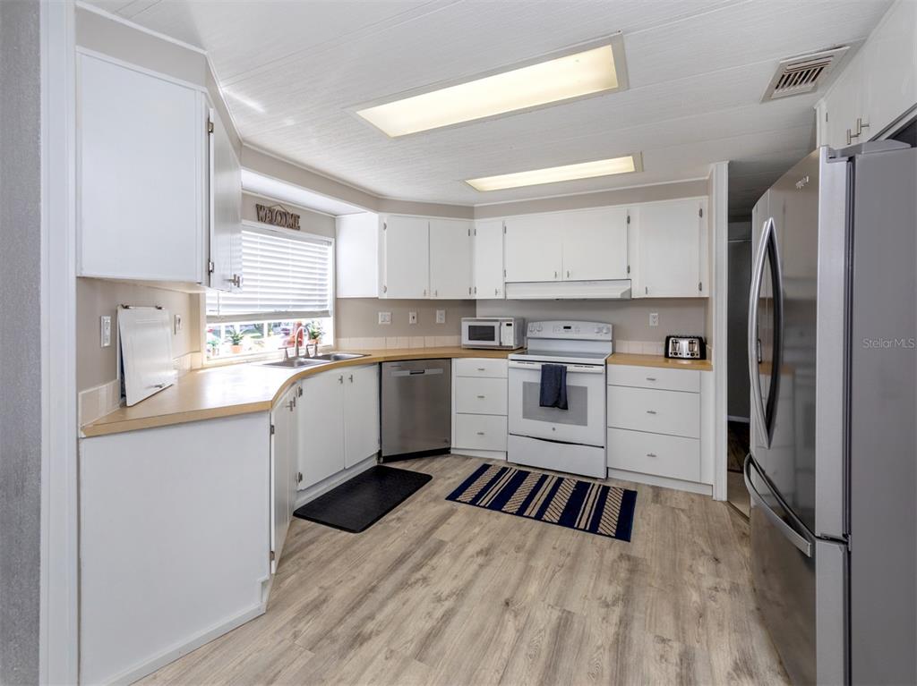 130 Lazy River Road North Port, FL 34287 - Photo 12 of 50 a kitchen with a refrigerator a sink and white cabinets