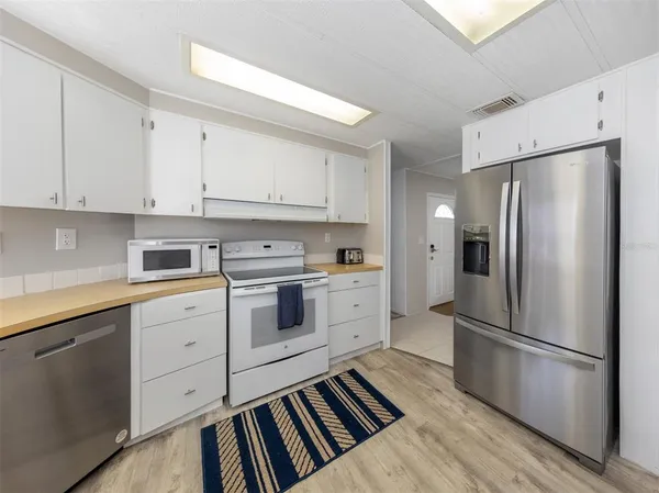 a kitchen with white cabinets stainless steel appliances and a refrigerator