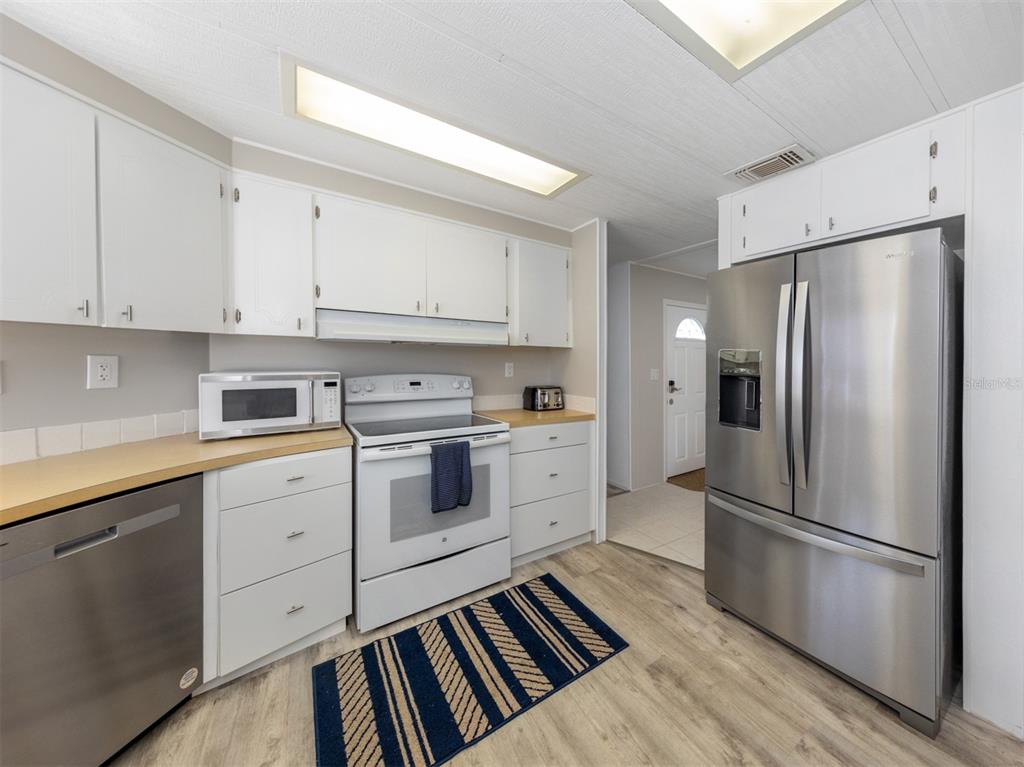 130 Lazy River Road North Port, FL 34287 - Photo 15 of 50 a kitchen with white cabinets stainless steel appliances and a refrigerator