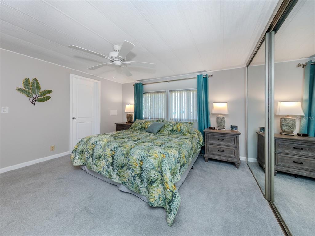 130 Lazy River Road North Port, FL 34287 - Photo 16 of 50 a spacious bedroom with a bed and a chandelier