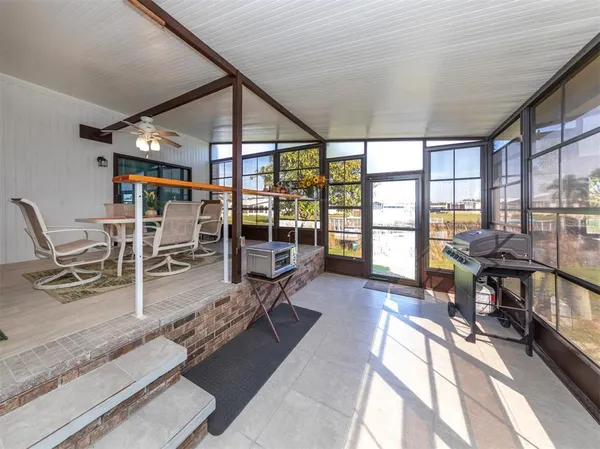 a dining room with furniture and a floor to ceiling window