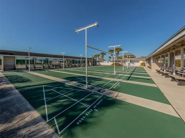 a view of a tennis ground with large trees