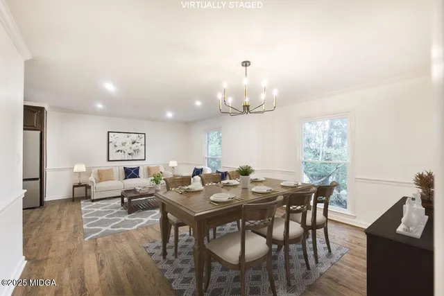 an empty room with wooden floor chandelier fan and windows