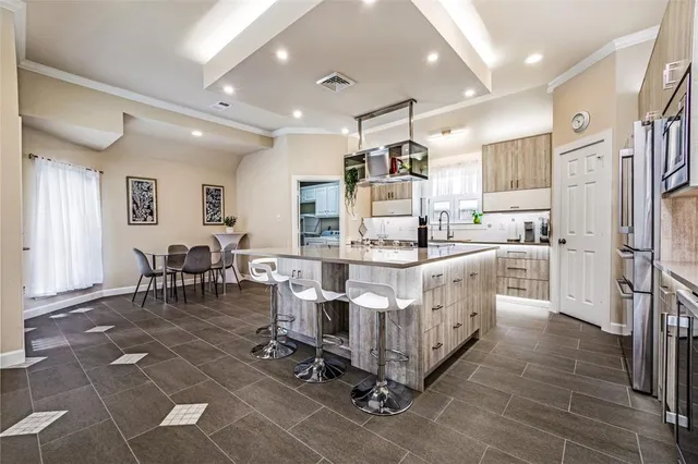 a large white kitchen with stainless steel appliances lots of white furniture