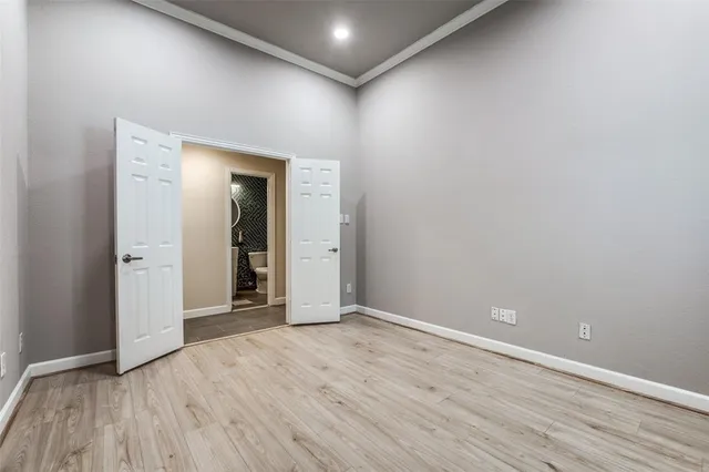 a view of an empty room with wooden floor and closet
