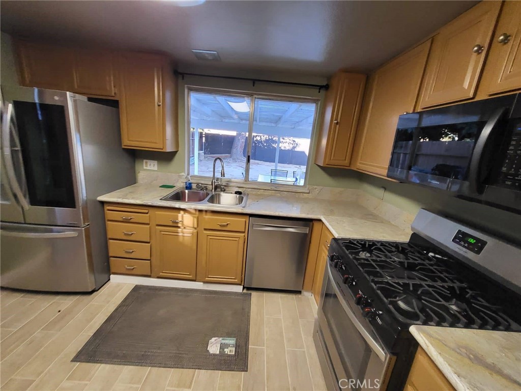 44025 Glenraven Road Lancaster, CA 93535 - Photo 2 of 5 a kitchen with a sink stove and refrigerator