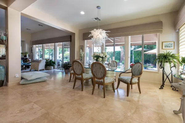 a view of a dining room with furniture a chandelier and wooden floor