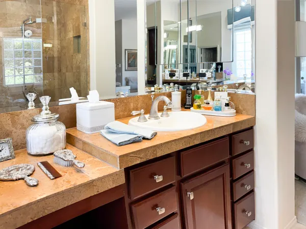 a bathroom with a sink vanity granite toilet and shower