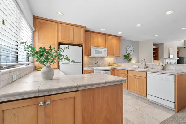 a kitchen with stainless steel appliances granite countertop a stove a sink a refrigerator and a microwave