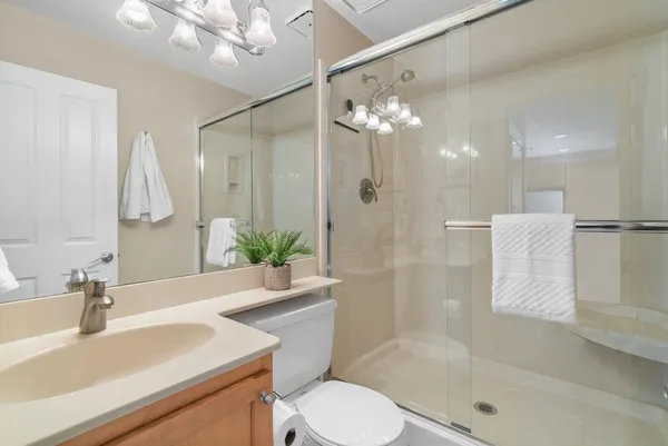 a bathroom with a sink a toilet and shower