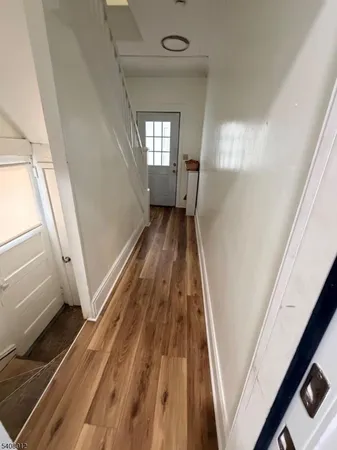 a view of a hallway with wooden floor and staircase