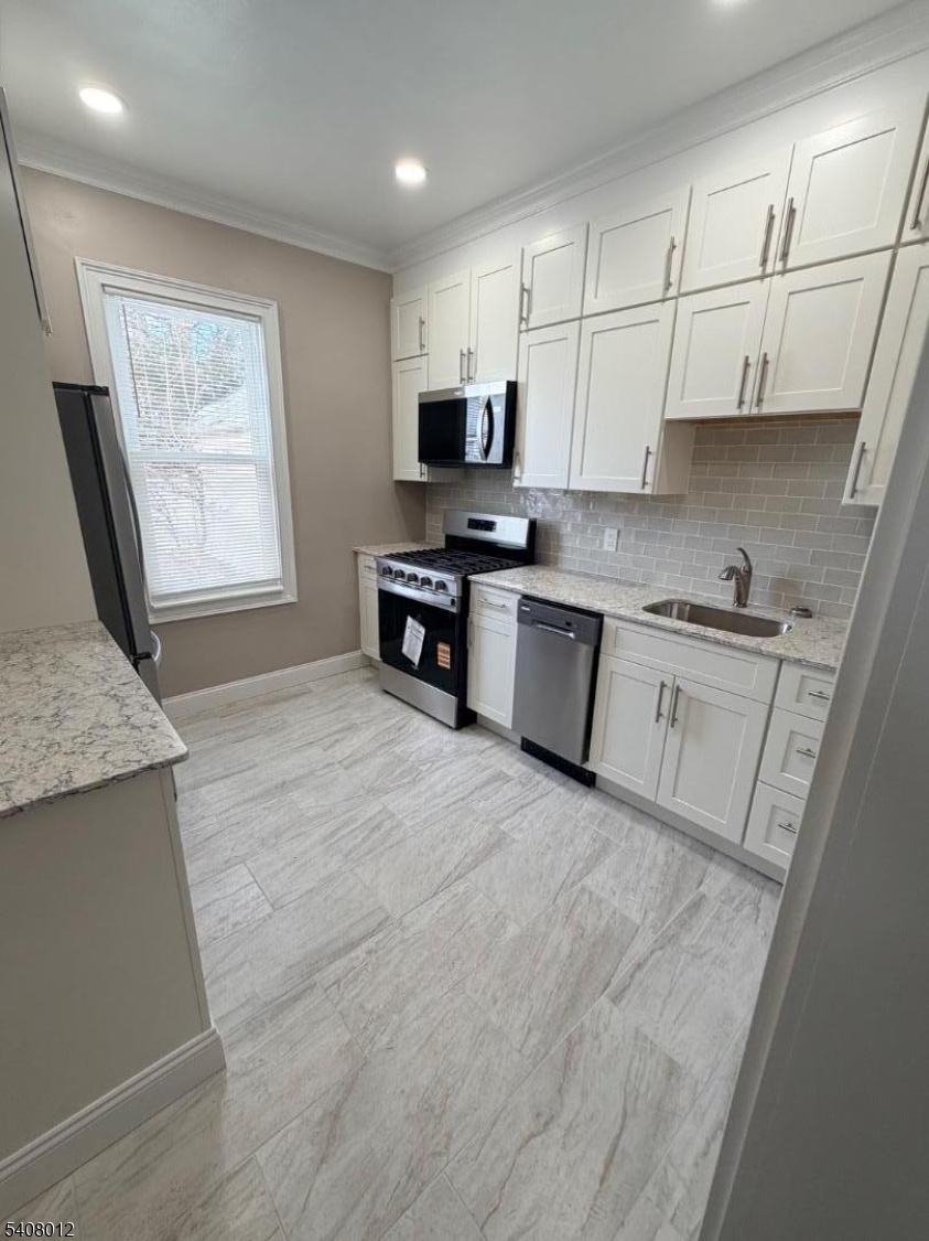 46 High Street, Unit 1 Clifton, NJ 07014 - Photo 2 of 14 a large kitchen with stainless steel appliances granite countertop a stove a sink dishwasher and a refrigerator with wooden floor
