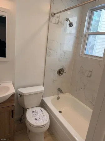 a white toilet sitting next to a bath tub