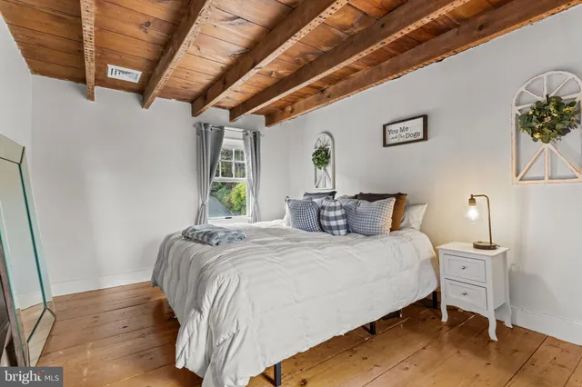 a bedroom with a bed a potted plant and a dresser