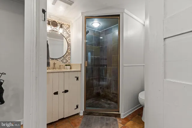 a bathroom with a glass shower door and a sink