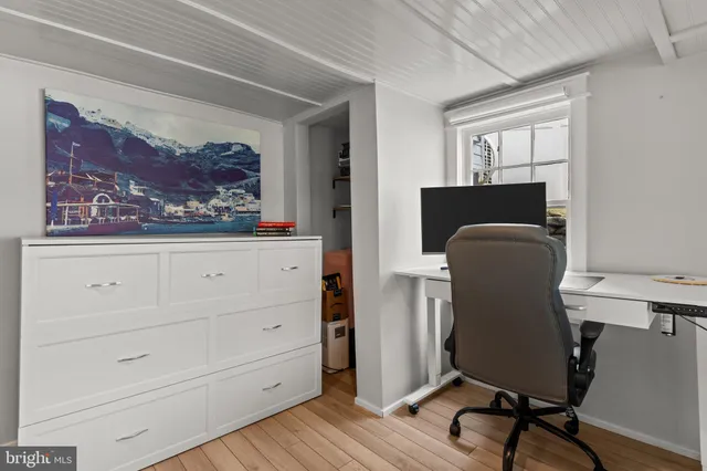 a view of a workspace with furniture and a window