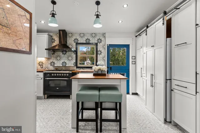 a kitchen with stainless steel appliances a stove a refrigerator and a dining table with painted walls