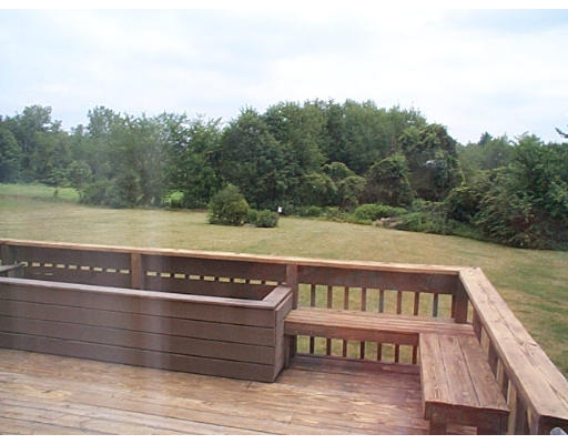 73 Heywood Road Sterling, MA 01564 - Photo 6 of 14 a view of wooden deck and lake with trees in the background