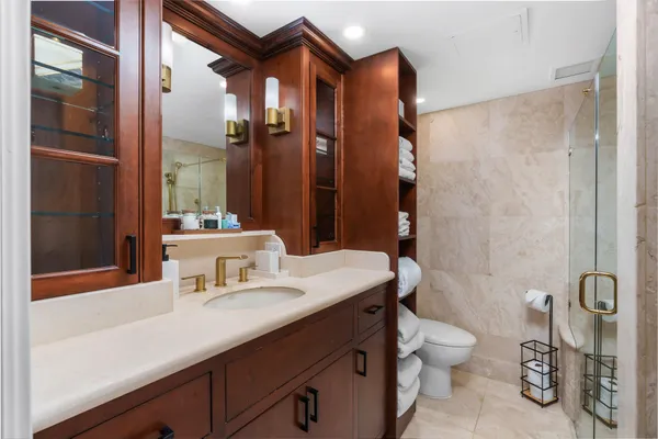 a bathroom with a sink a toilet and shower