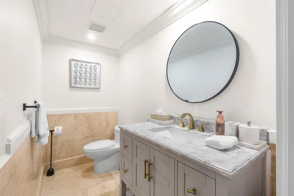 a bathroom with a granite countertop toilet a sink and a mirror