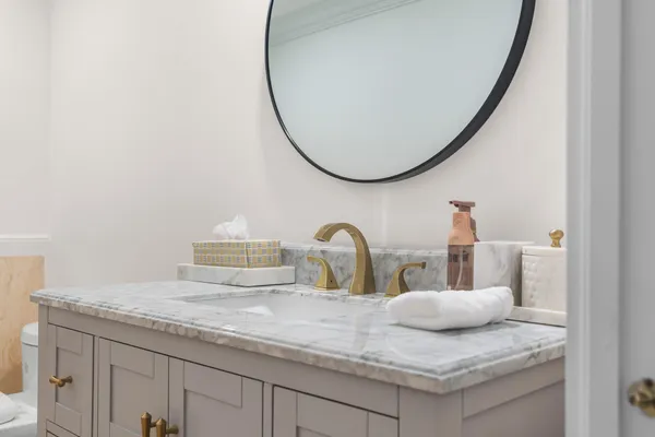 a bathroom with a granite countertop sink and a mirror
