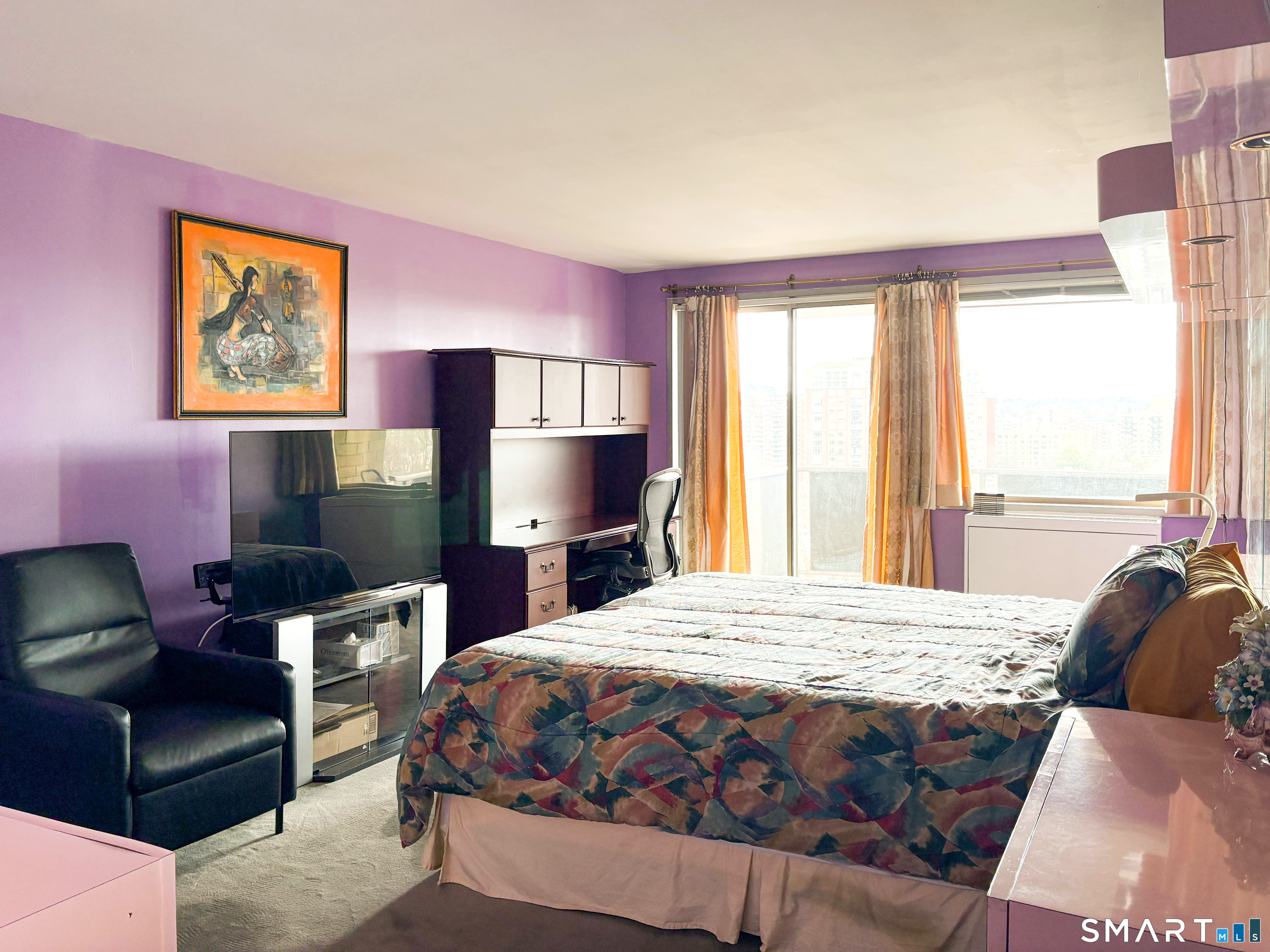 50 Glenbrook Road, Unit 9C Stamford, CT 06902 - Photo 5 of 20 a bedroom with a bed a couch and a flat tv screen next to a window