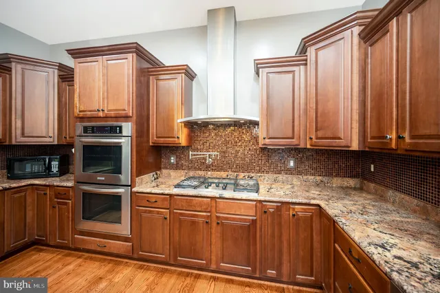 a kitchen with granite countertop a sink stove and cabinets