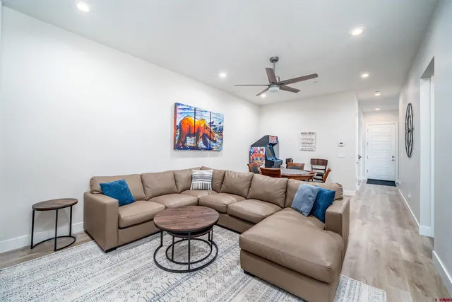 a living room with furniture kitchen view and a chandelier