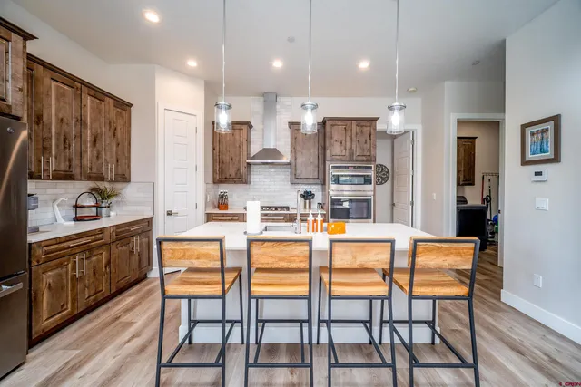 a dining hall with stainless steel appliances kitchen island granite countertop a dining table and chairs