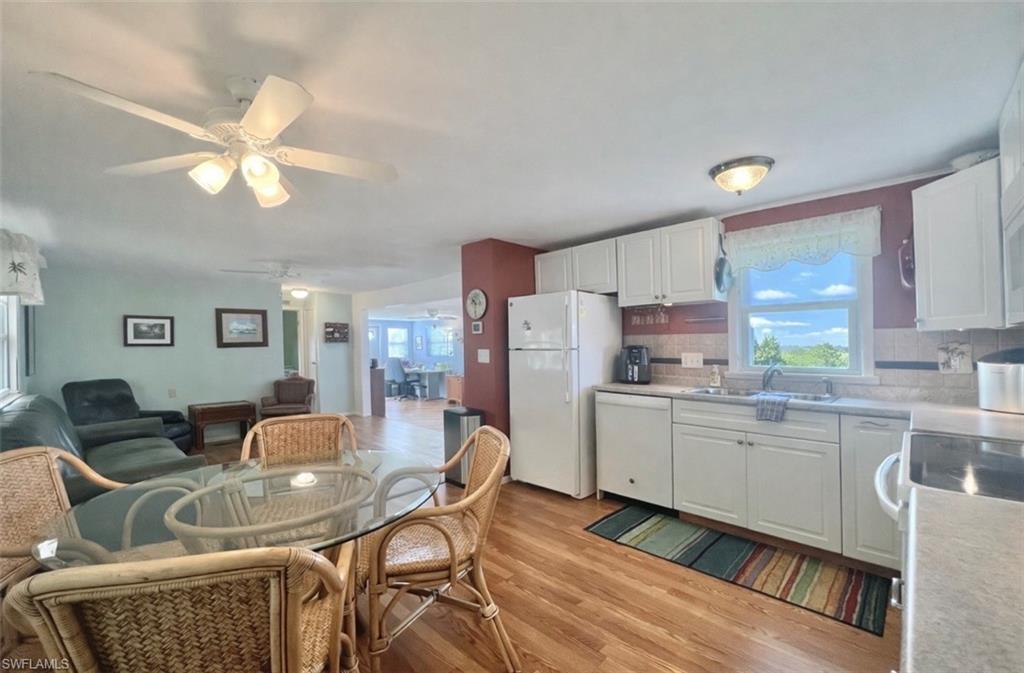 273 Cape Sable Drive Naples, FL 34104 - Photo 11 of 49 a kitchen with a dining table chairs refrigerator and cabinets