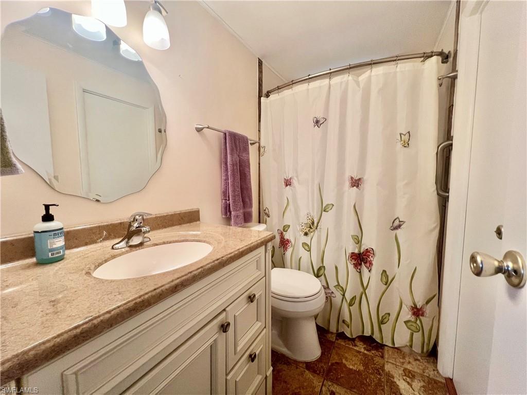 273 Cape Sable Drive Naples, FL 34104 - Photo 22 of 49 a bathroom with a granite countertop sink a toilet and a mirror